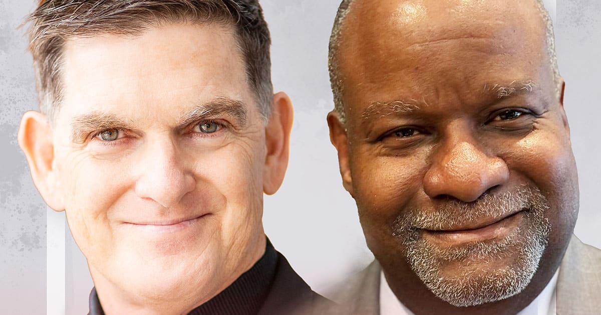 Two men are smiling. Derek Mitchell, on the left, has short brown hair and wears a black shirt. Scott Sampson, on the right, with short hair and a beard, dons a gray suit. Both are set against a neutral background, embodying the spirit of regenerative education in their poised presence.